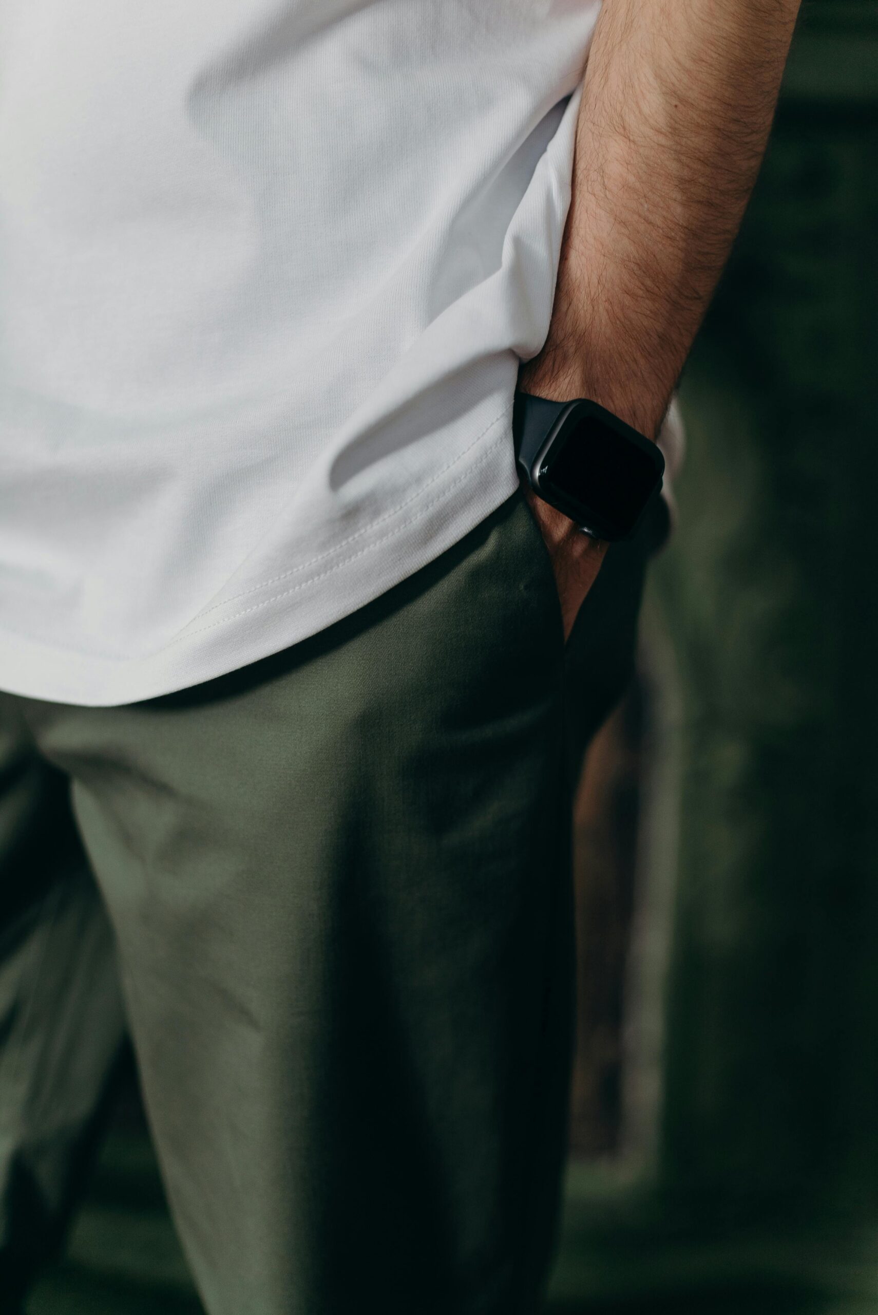 Close-up of a man wearing a white t-shirt and smartwatch in a casual setting.
